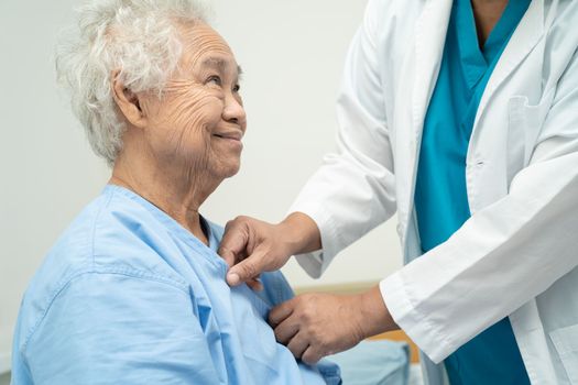 Doctor checking senior or elderly old lady woman patient lie down in nursing hospital ward, healthy strong medical concept.