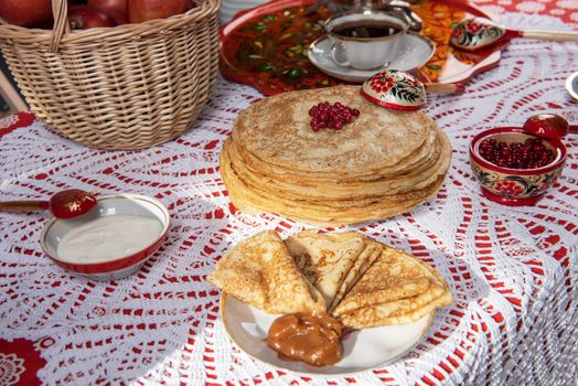 Pancakes with berries and sour cream on the table. Shrovetide Maslenitsa festival concept.