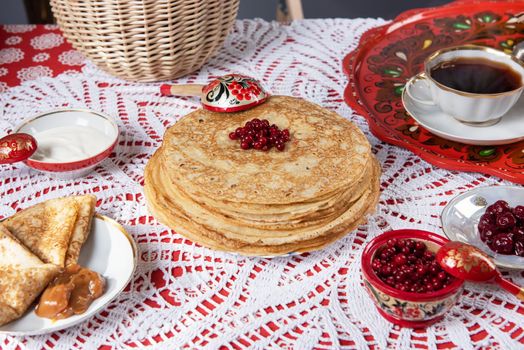 Pancakes with berries and sour cream on the table. Shrovetide Maslenitsa festival concept.