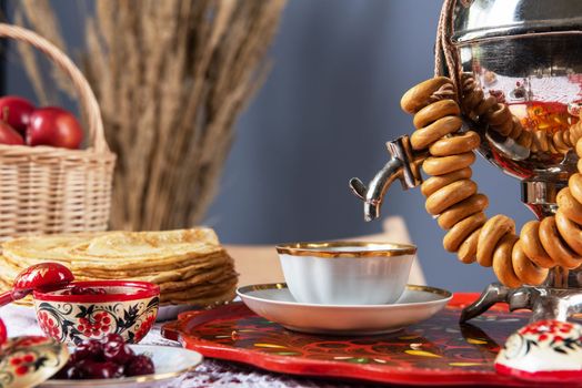 Pancakes with berries and sour cream, samovar and drying on the table. Shrovetide Maslenitsa festival concept.