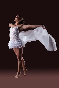 Strong woman body builder in ballet lingerie with flying veil