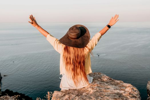 Portrait of happy young woman wearing summer black hat with large brim at beach on sunset. Closeup face of attractive girl with black straw hat. Happy young woman smiling and looking at camera at sea