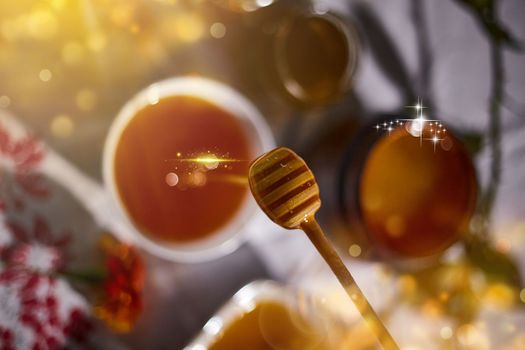 a jar of sweet honey on a table from the garden with apples in a glass