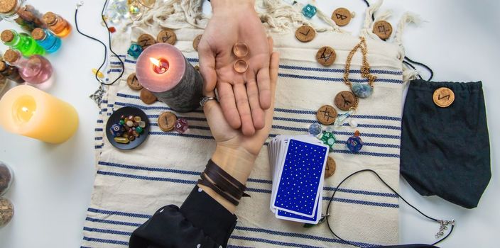 A woman fortuneteller tells a man on tarot cards. Selective focus. People.
