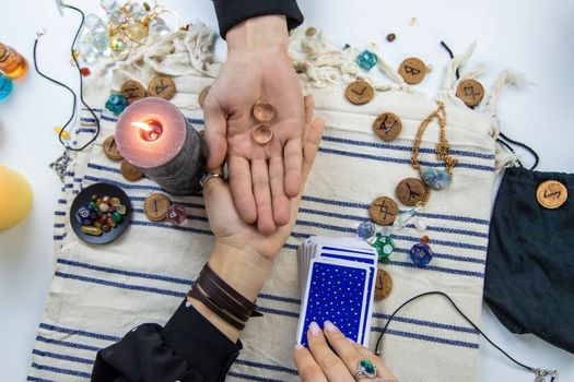 A woman fortuneteller tells a man on tarot cards. Selective focus. People.