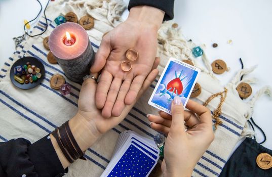 A woman fortuneteller tells a man on tarot cards. Selective focus. People.