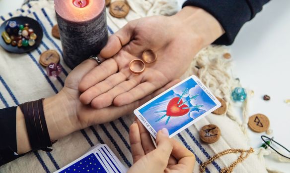 A woman fortuneteller tells a man on tarot cards. Selective focus. People.