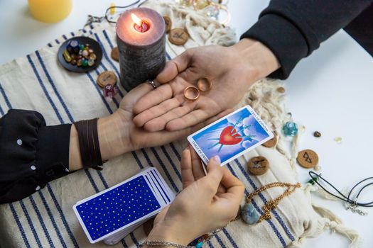 A woman fortuneteller tells a man on tarot cards. Selective focus. People.