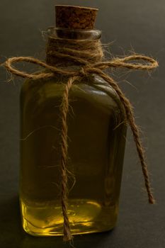 close-up of a glass bottle with cork stopper containing rosemary healing oil