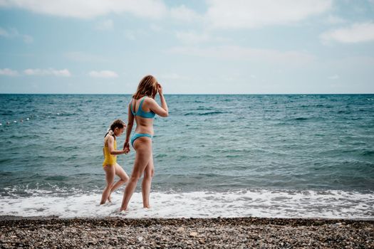 Mother and daughter having fun on tropical beach - Mum playing with her kid in holiday vacation next to the ocean - Family lifestyle and love concept