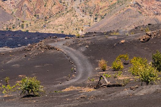Pathway through the crater of Pico do Fogo volcano with old and new dark lava flow, Cape Verde islands