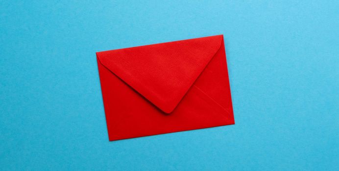 Red envelope isolated on blue background with copyspace. Concept of communication, delivery and correspondence. Old school contact post service