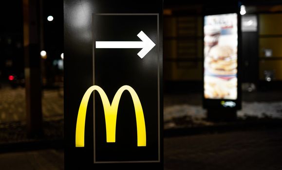 Kyiv, Ukraine - 05 Fabruary 2021: Yellow signboard of McDonalds restaurant with white arrow showing way to McDrive