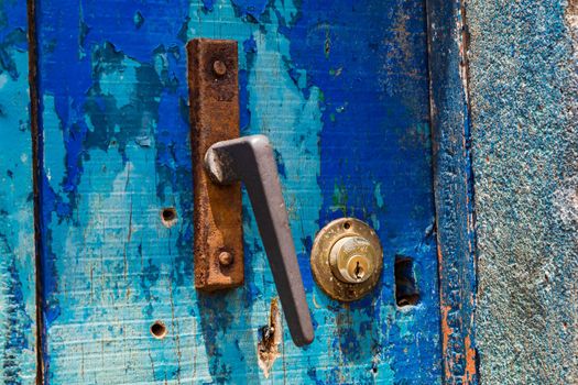 An old rusted doorknob with a lock on an old blue door, Cape Verde Islands, Africa