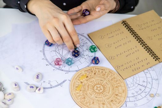 Woman numerologist astrologer counts numbers. Selective focus. People.