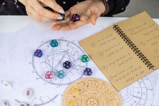 Woman numerologist astrologer counts numbers. Selective focus. People.