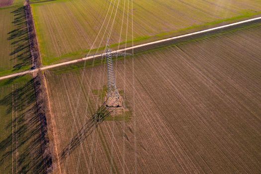 Aerial view of power lines on a high voltage pylon in a rural field