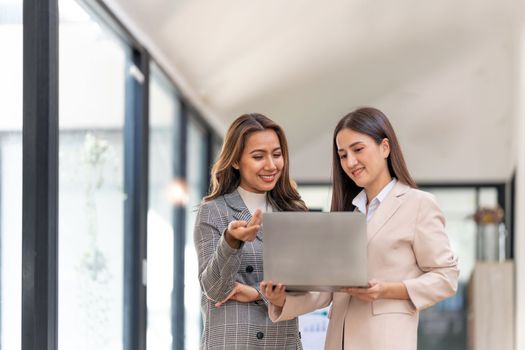 Young colleagues discuss business and analytical price charts using calculators and laptops to calculate financial, tax, accounting, statistics and analytical research.