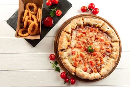 Set of pizza and snacks on a white background. Margarita pizza and snacks onion rings fried in breading.