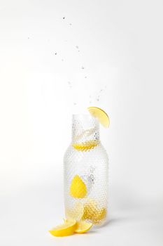 Glass of lemonade with splashing water on white background drink