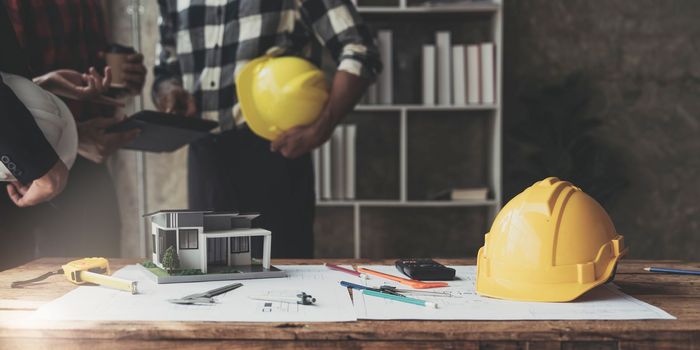 Civil engineer teams meeting working together wear worker helmets hardhat on construction site in modern city. Foreman industry project manager engineer teamwork. Asian industry professional team...