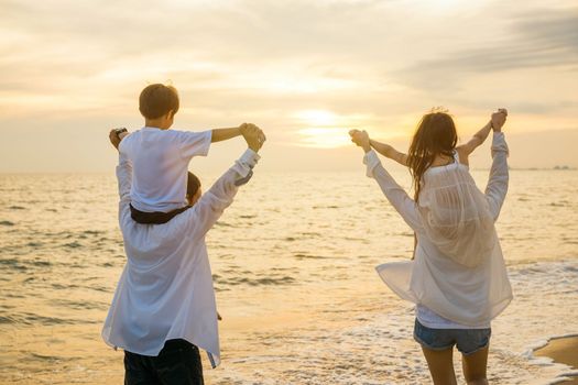 Happy family day. Parents carrying children on shoulders at the beach on sunset time, Father, Mother and kids playing together outdoors on summer beach, Family on holiday summer vacation travel