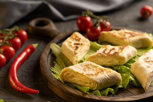 Delicious fried pita bread roll with cottage cheese and herbs. Fried puff rolls of thin Armenian lavash stuffed with cottage cheese. Wrapped tortillas. Traditional cuisine. Delicious and healthy food.