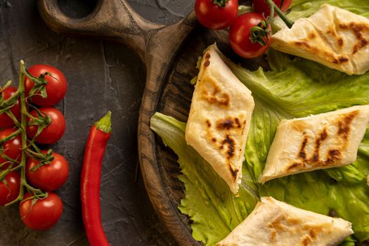 Delicious fried pita bread roll with cottage cheese and herbs. Fried puff rolls of thin Armenian lavash stuffed with cottage cheese. Wrapped tortillas. View from above.