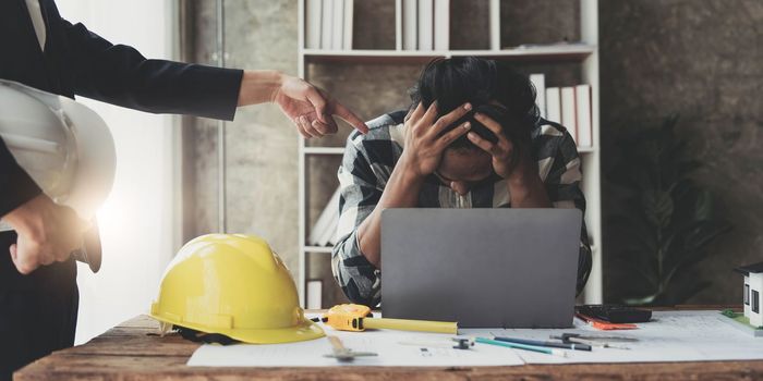 Engineer man stress in work because his boss complaining to him about mistake to manage project in the meeting room at modern office.Mistake project management concept...