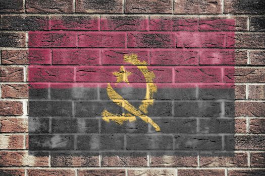 An Angola flag on a brick wall background