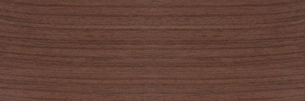 Texture of wenge wood. Dark brown wenge background. Natural brown wood texture, solid natural wood for furniture production.