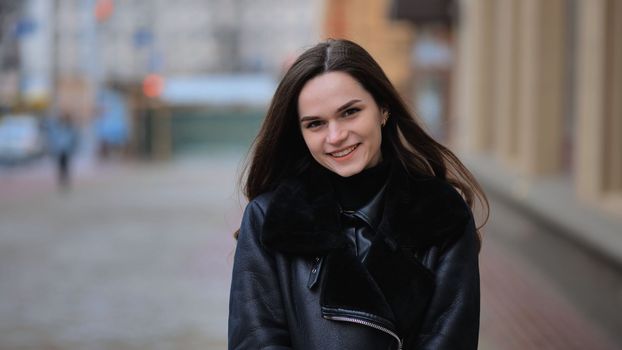 Portrait of a posing happy girl in the city in early spring