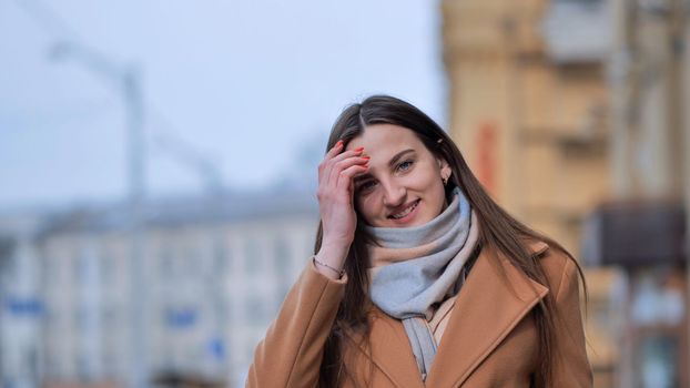 Portrait of a posing happy girl in the city in early spring