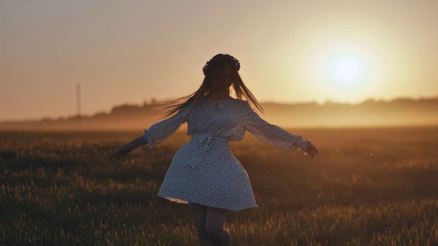 A silhouette of a young Ukrainian girl circling at sunset in the summer