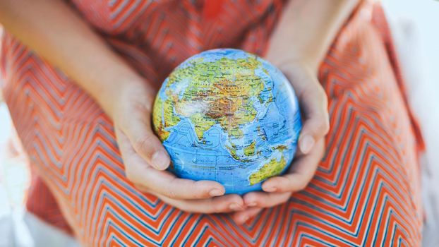 The little one is holding a geographic globe