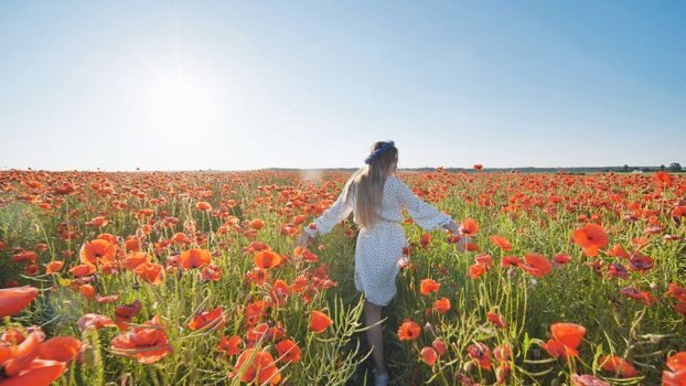 Ukrainian girl walking through a red poppy field