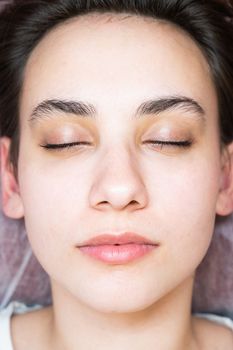 Woman lying on the couch after eyelash lamination procedure