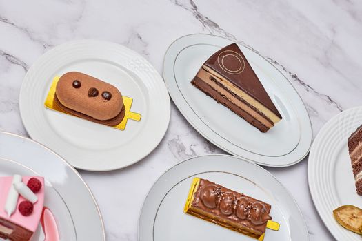 different desserts on white plates with gold trim around the edges and one chocolate cake in the other plated