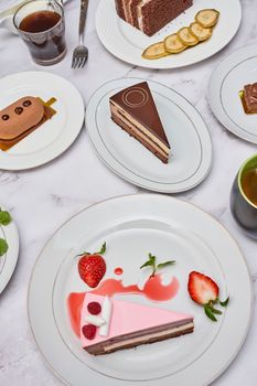 some desserts on plates with strawberries, bananas, chocolate and other food items in the table is white