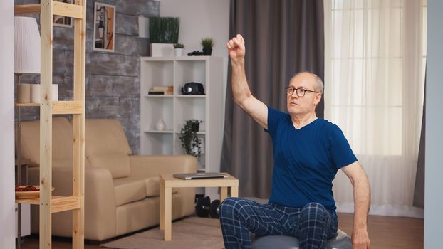 Senior man doing warm up exercise before fitness training. Old person pensioner healthy training healthcare sport at home, exercising fitness activity at elderly age
