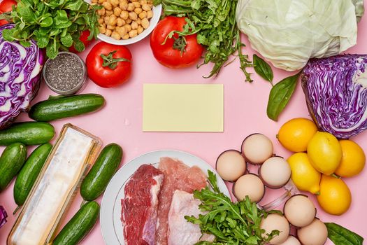 food on a pink surface with vegetables, eggs, and other foods that are in the same place to be eaten