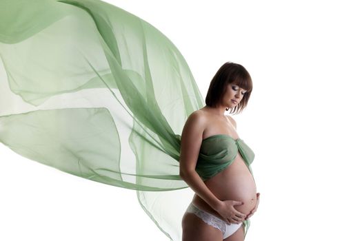 Beautiful pregnant woman with green blowing fabric. Isolated on white