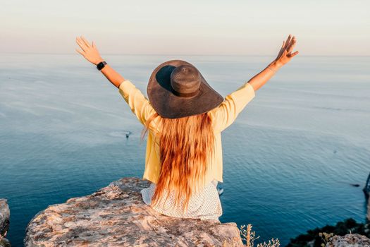 Portrait of happy young woman wearing summer black hat with large brim at beach on sunset. Closeup face of attractive girl with black straw hat. Happy young woman smiling and looking at camera at sea