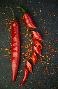 Red chili pepper cut into pieces on a black background. Hot spice, red chili