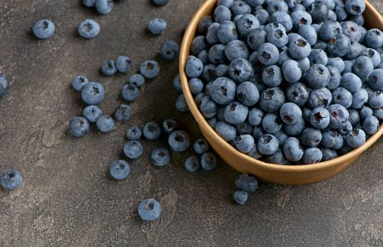 freshly picked blueberries close up with water drops on wood background