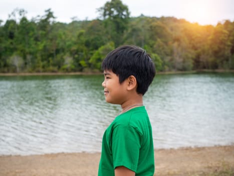 A boy stands by the reservoir in the evening. It shows looking at the goals in life.