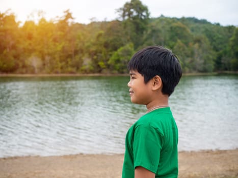 A boy stands by the reservoir in the evening. It shows looking at the goals in life.