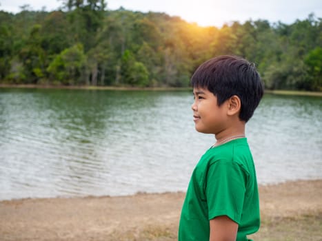 A boy stands by the reservoir in the evening. It shows looking at the goals in life.