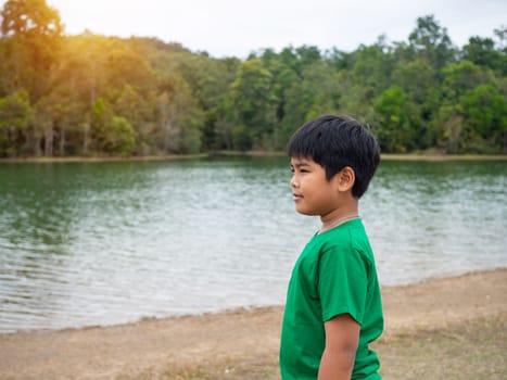 A boy stands by the reservoir in the evening. It shows looking at the goals in life.