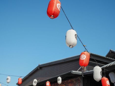 Japanese lantern hung in front of Japanese Restaurant, Japanese text on lantern is "Sushi" Japanese food.